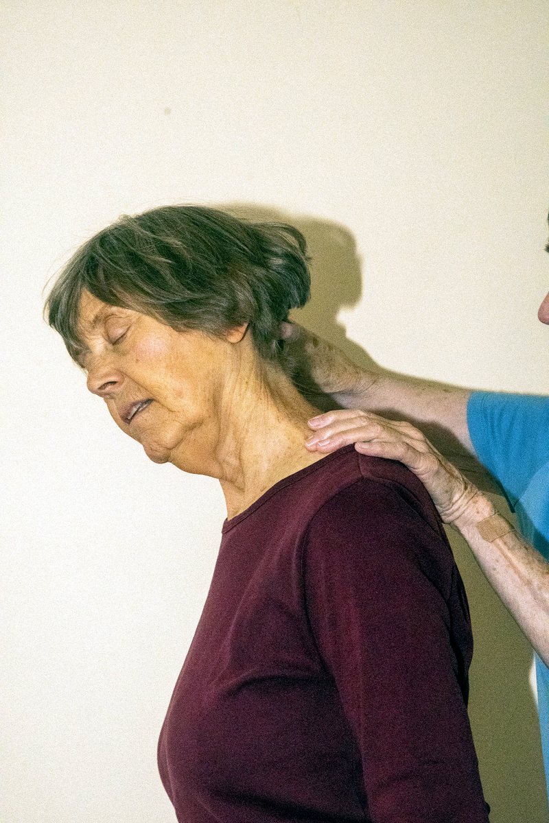 A gentle hand at the neck and shoulder, inviting release