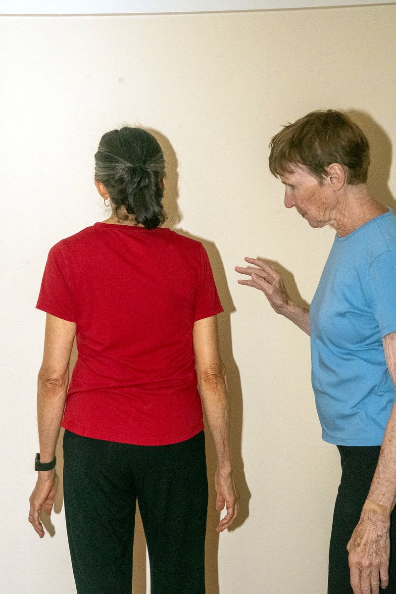 Linda observing a client's shoulders and neck from behind