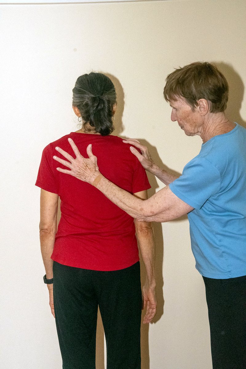 A listening hand resting between the shoulder blades