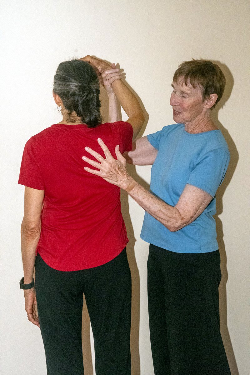 Supporting the shoulder as the client raises an arm overhead